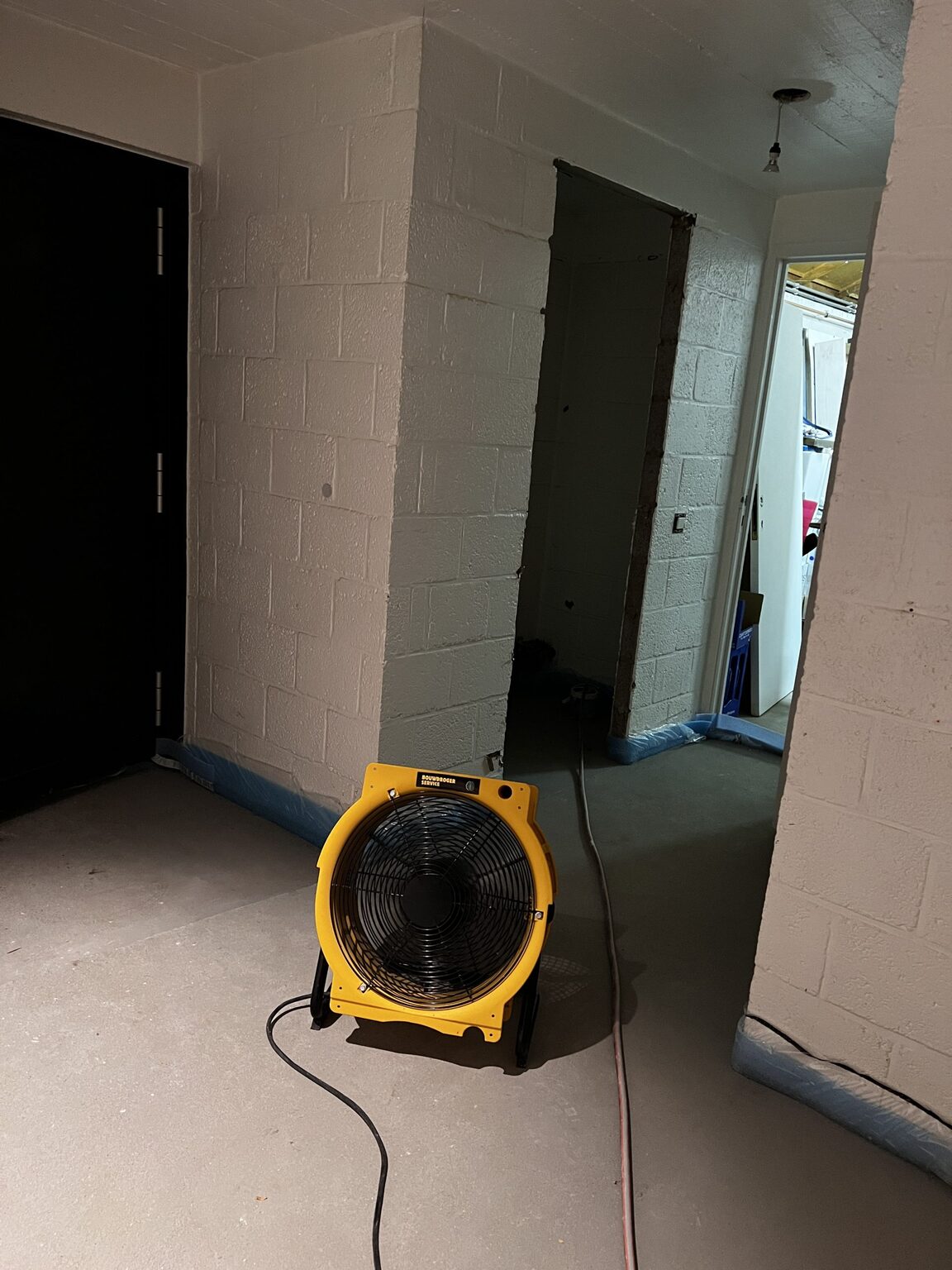 Krachtige ventilator stuwt de vochtige lucht door de gang in het ruwe metselwerk