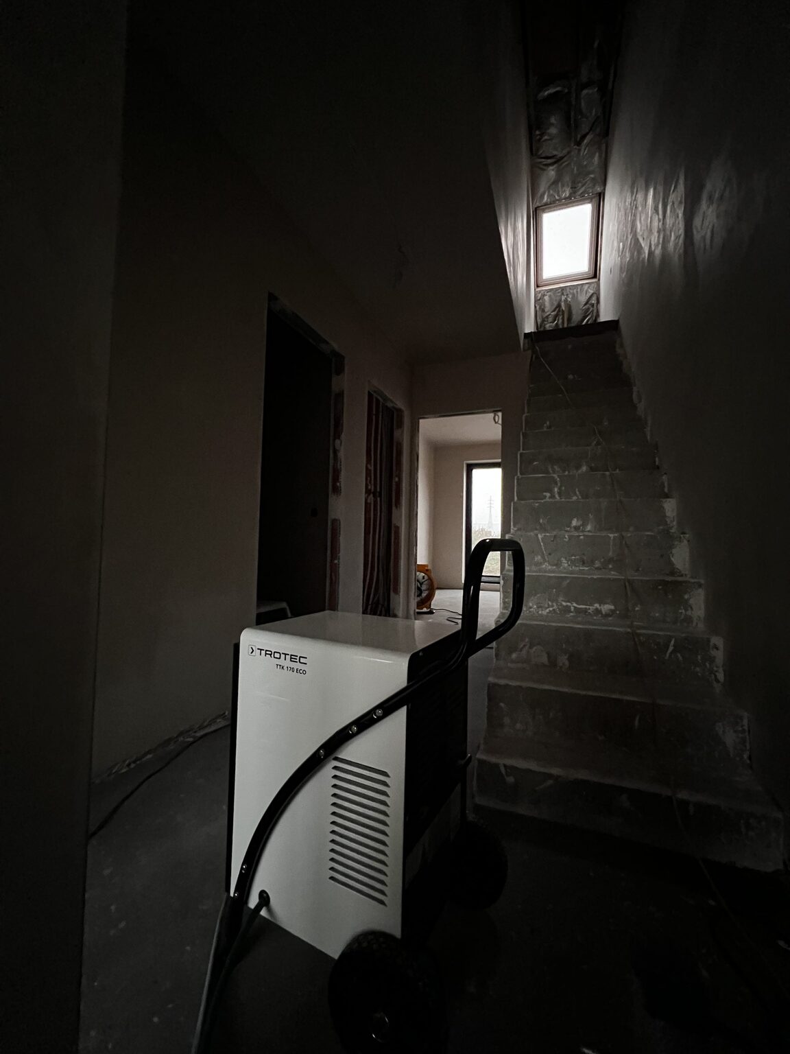 Bouwdroger onderaan de traphal in de woning