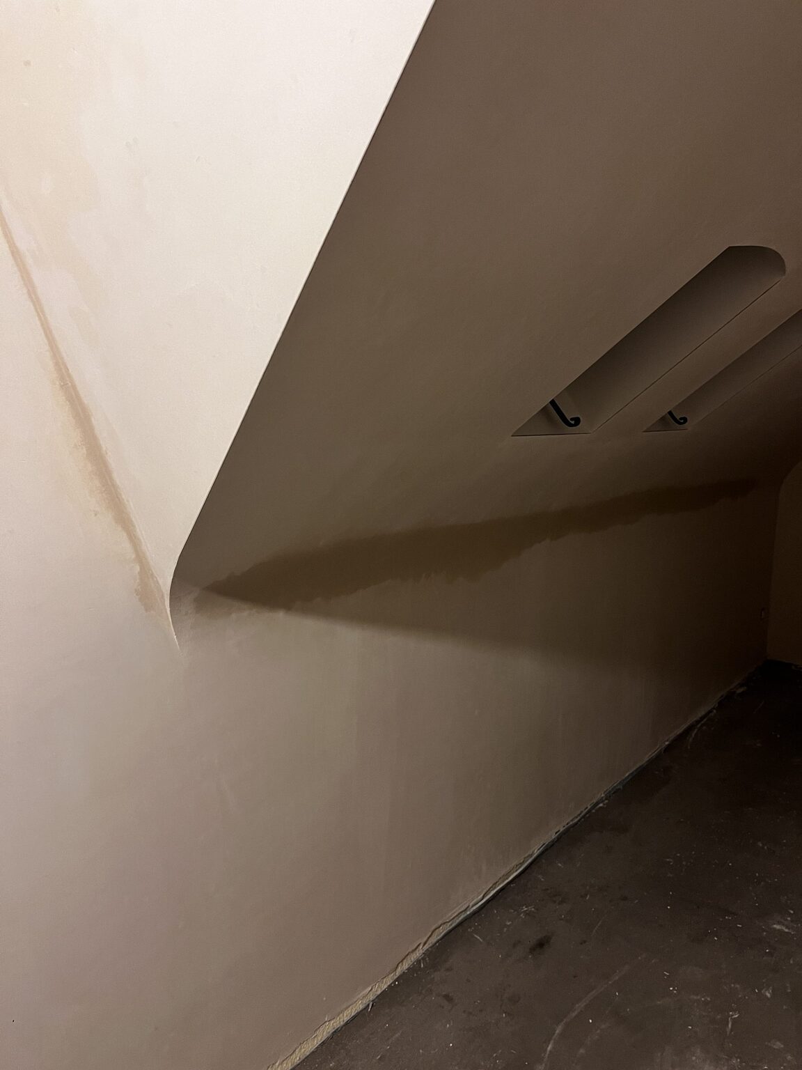 Vers pleisterwerk met een vochtrand tegen het plafond