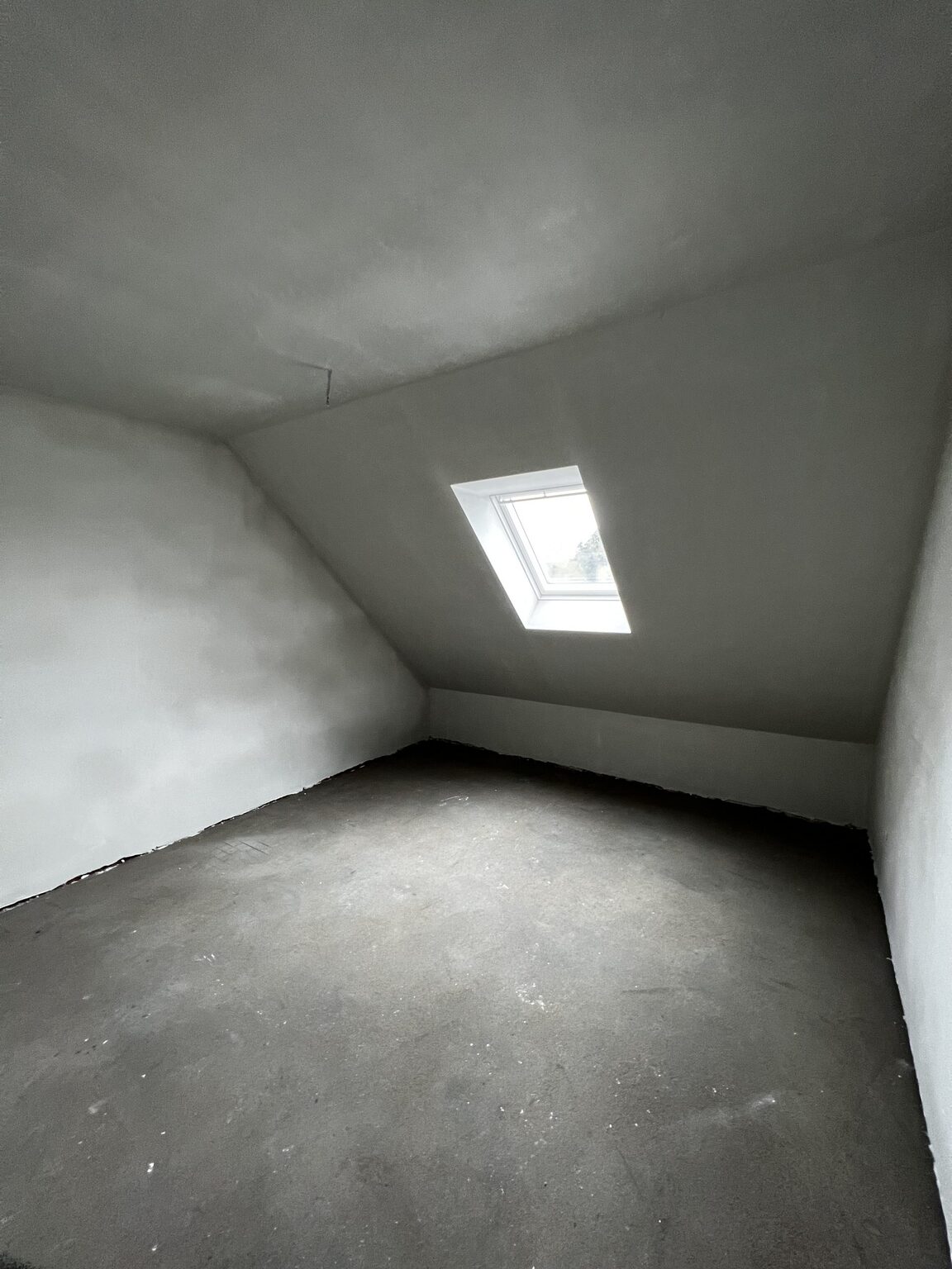 Kamer onder het dak met dakvenster in de nieuwbouwwoning