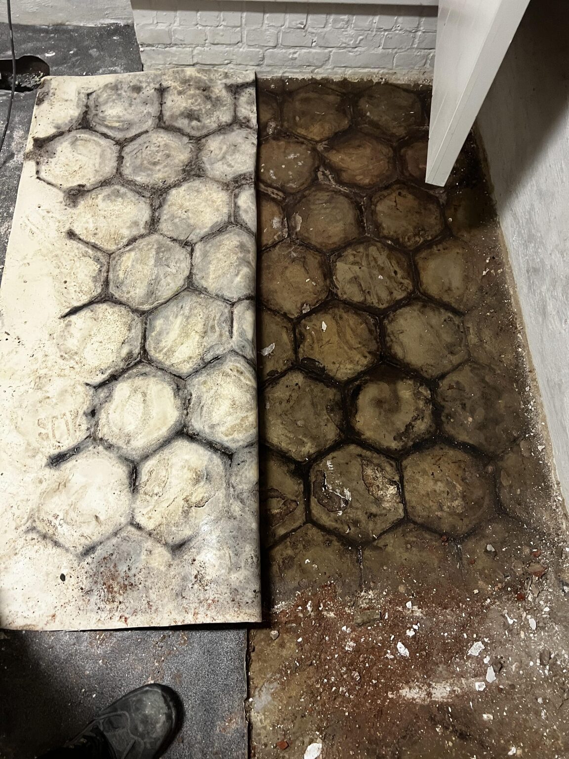 De oude cementtegelvloer uitgebroken tijdens de werken
