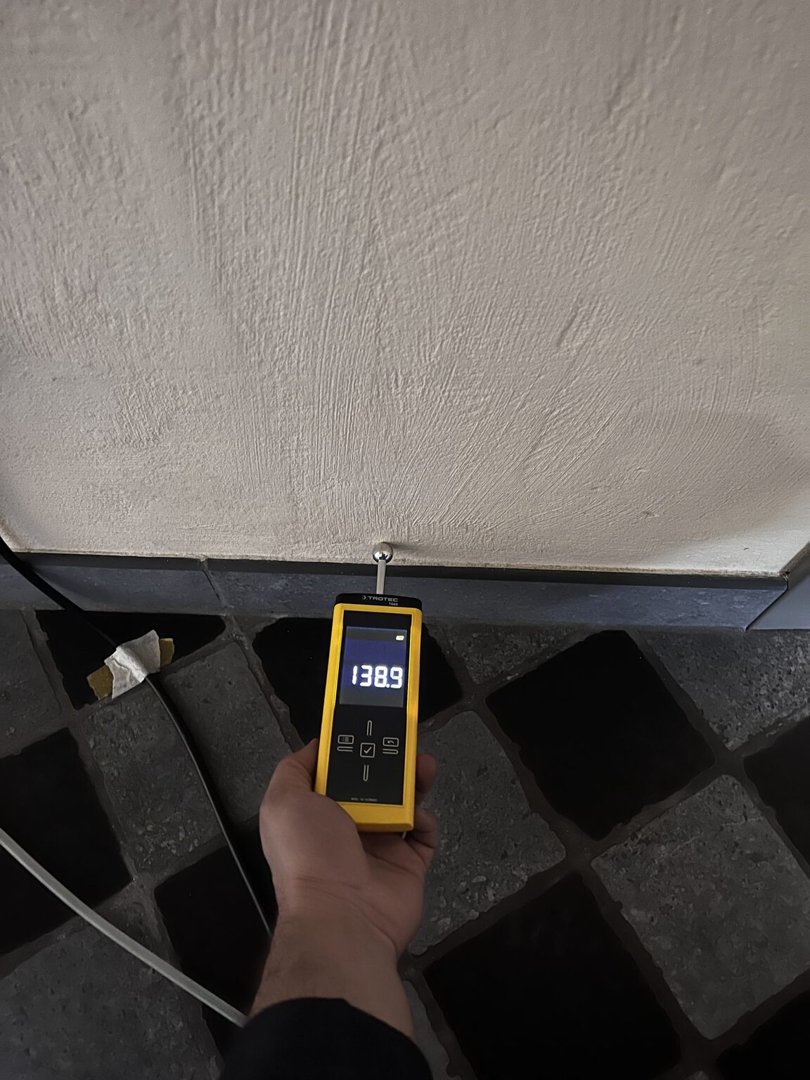 Vochtmeting op de witgepleisterde wand