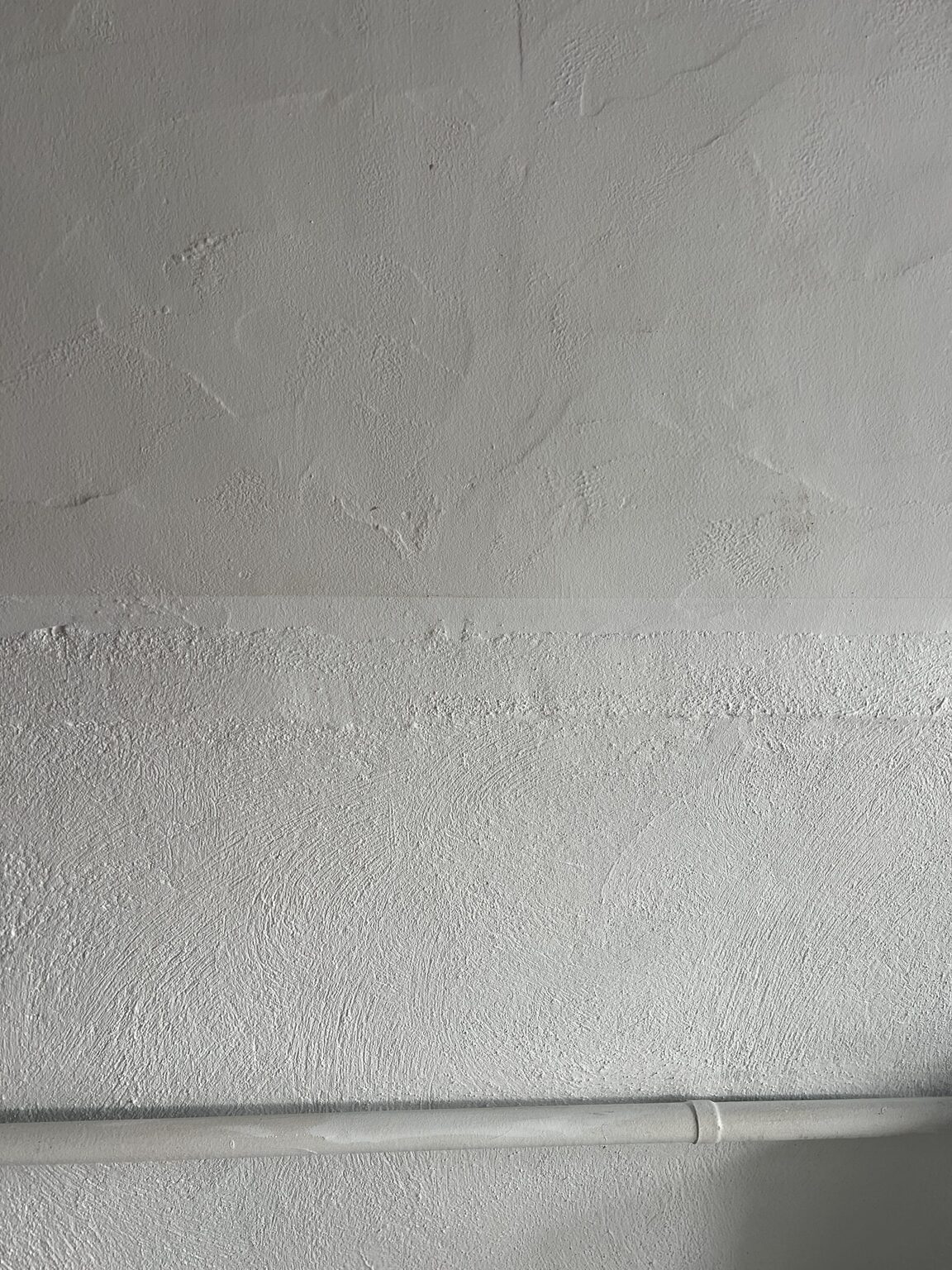 Afgewerkte muurhoek met beschermtape aan de vloer